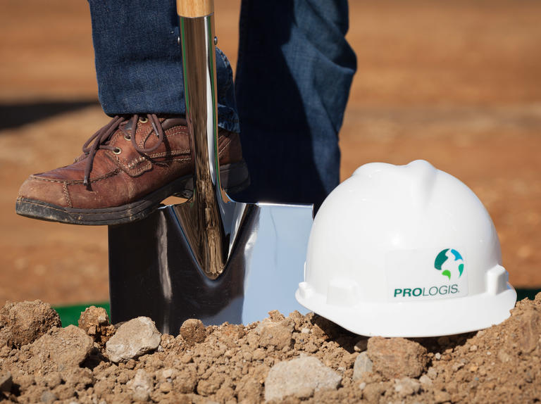 person shoveling with prologis safety helmet