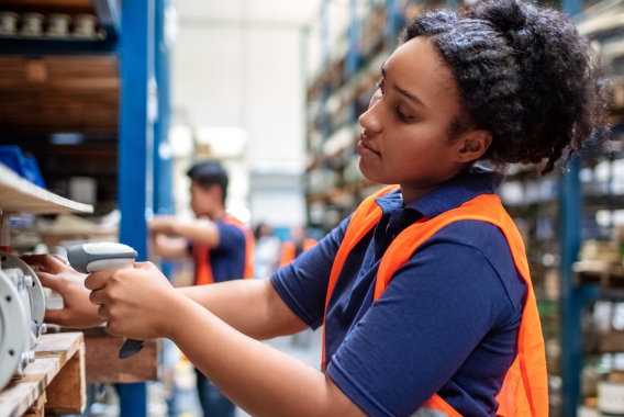 Woman scanning with barcode scanner in a warehouse