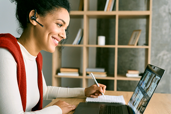 Woman following online training behind her laptop