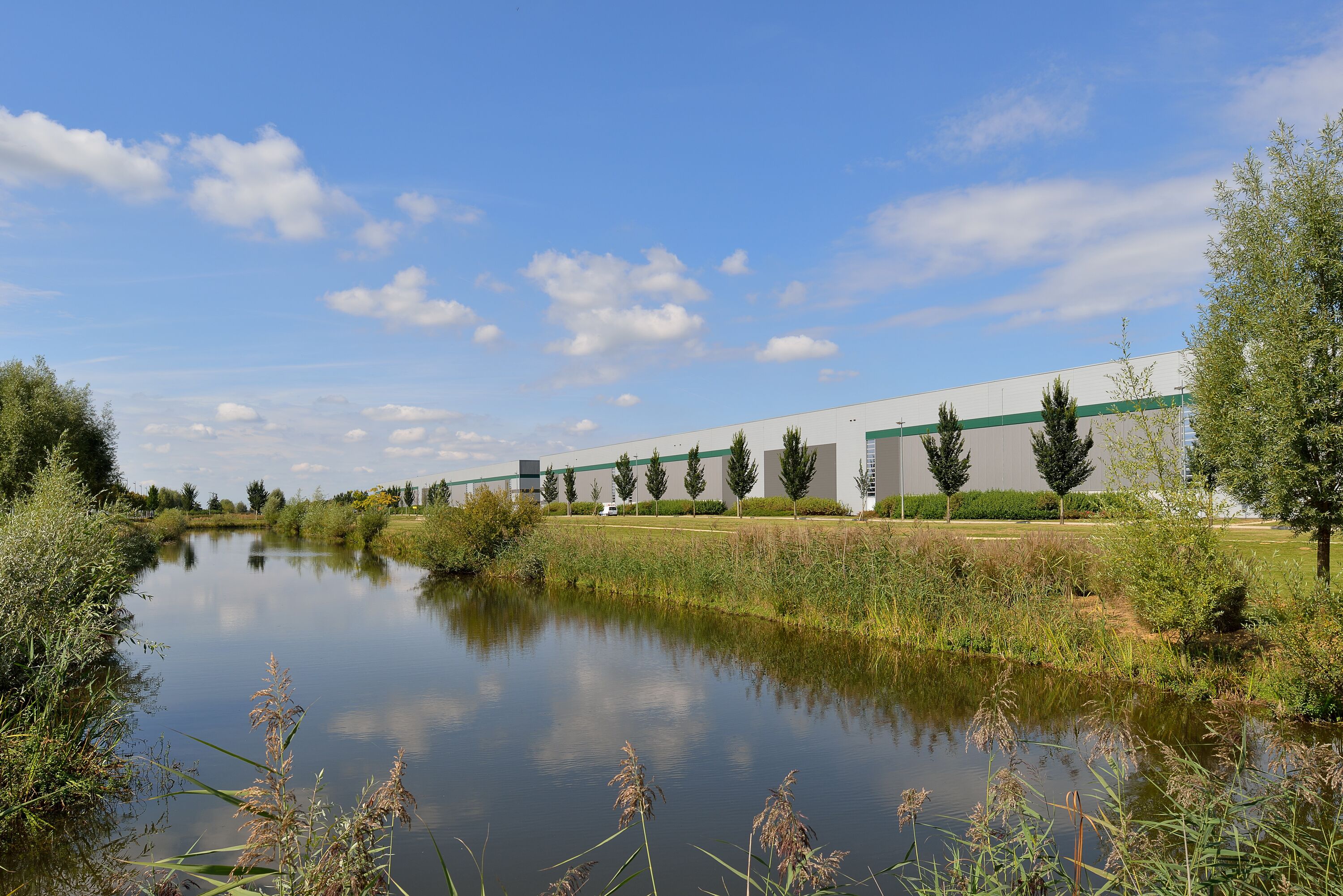 A warehouse with trees and a river in the background